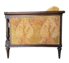 A Neoclassical-style wooden loveseat with a dark mahogany frame featuring scrolled arms and tapered legs. The upholstery consists of plush cushions and two matching cylindrical bolster pillows, all covered in a golden-yellow jacquard fabric with a large-scale, repeating autumnal leaf pattern in shades of muted orange and brown.