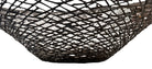 A round metal wall sculpture by Michael Aram, viewed from the front against a stark white background. The piece is composed of a dense, intricate lattice of fine, dark metal wire or twigs woven together to create a textured, web-like pattern. The structure curves inward like a funnel or a vortex, sloping down toward a clean, circular opening in the exact center, creating a strong sense of depth and dimensionality.