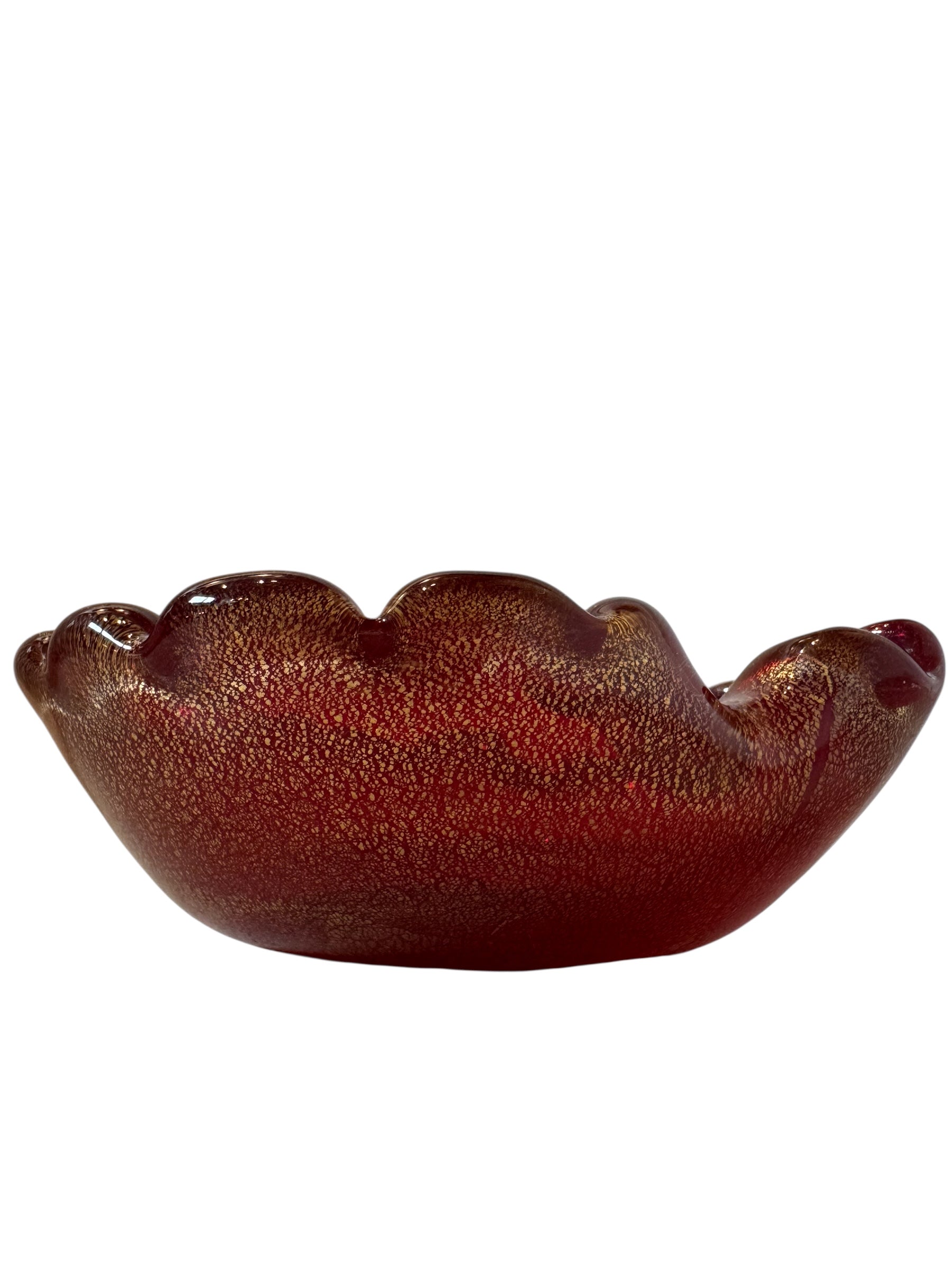 A handcrafted Murano glass bowl with a ruffled edge, deep red color, and gold specks created using the "oro zecchino" technique. The surface has a crackled gold pattern that reflects light, making it a striking decorative piece.