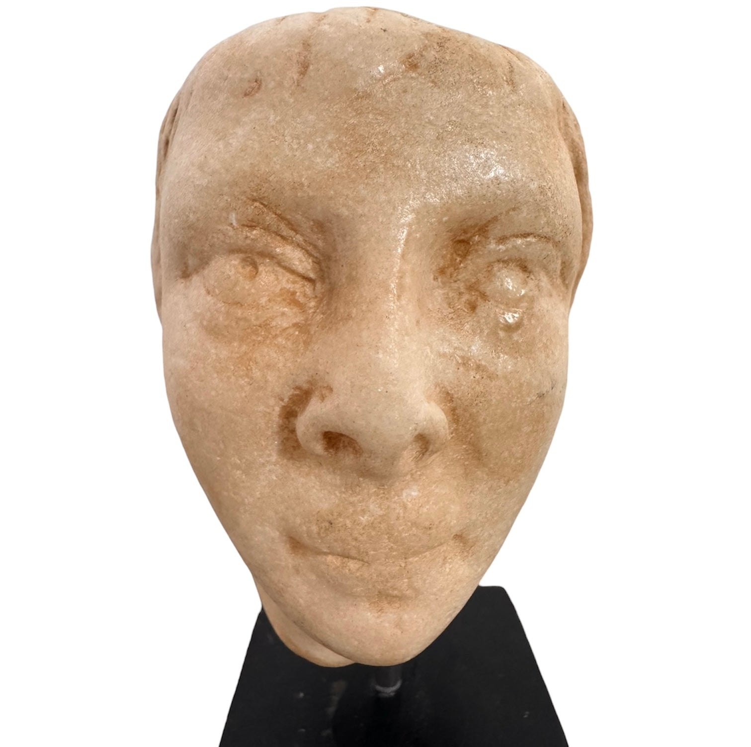 An ancient marble sculpted head of a young man, presented on a modern black presentation stand. The sculpture is rendered in a three-quarter view, angled slightly to the right, showing a classical profile characterized by a strong nose, softly contoured cheekbones, and slightly parted lips that convey a quiet, contemplative expression. The hair is carved in short, stylized strands that frame the forehead and ears, characteristic of ancient Roman or Greek portraiture styles.