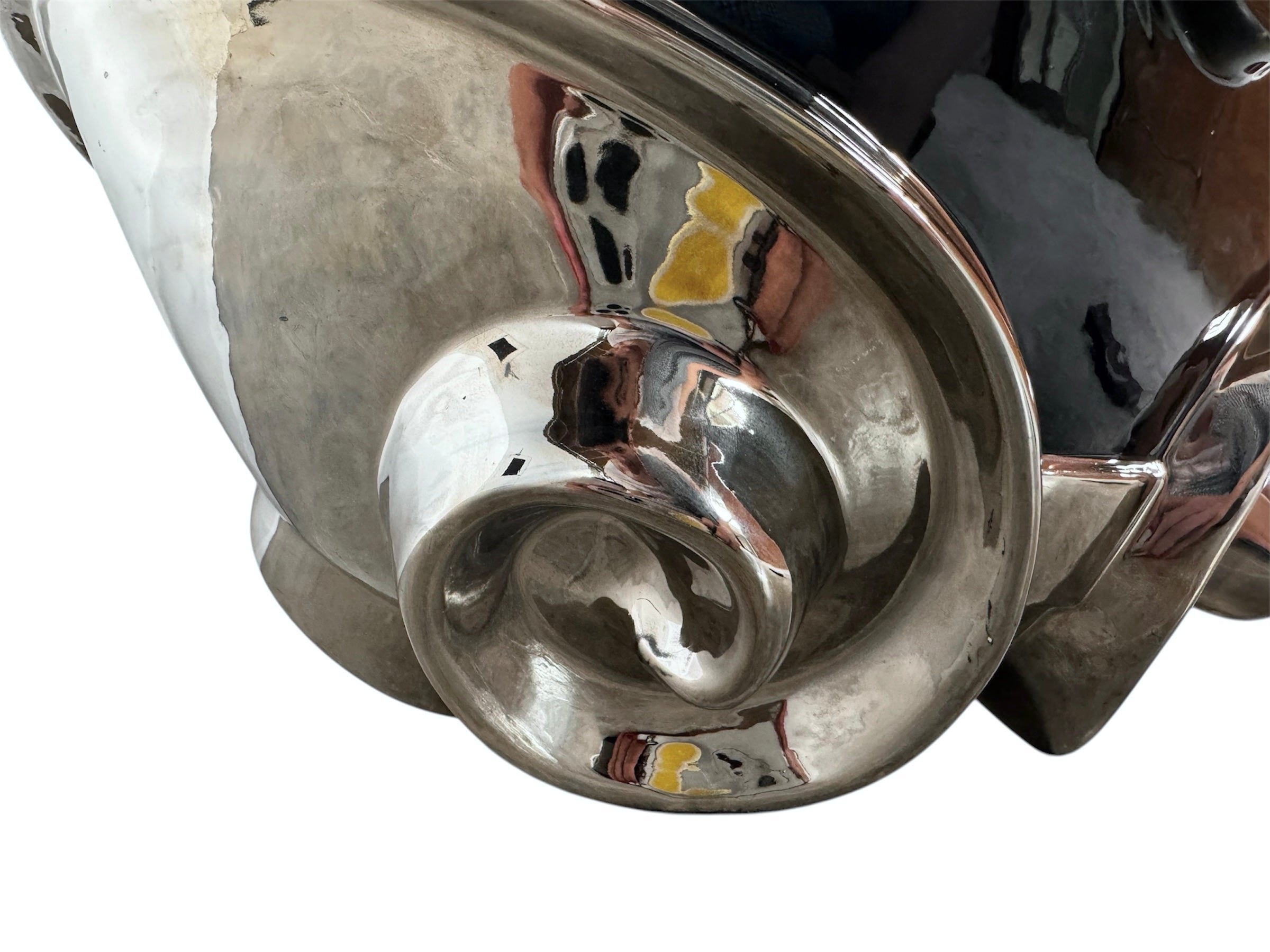 A large, decorative ceramic bowl by Dolbi Cashier in a dramatic Postmodern style. The top half is finished in a polished, piano-black glaze with an organic, wavy "butterfly" rim that dips in the center and rises at the sides. The bottom half is finished in a reflective, metallic silver chrome glaze, featuring bold, geometric-rounded feet and a structured base that appears to "hold" the black vessel. The overall shape is wide and sculptural, reminiscent of 1980s Art Deco Revival.