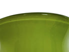 A mid-century modern, lime green cased-glass vase with a wide, flared rim and a thick, clear glass base. The exterior is a glossy chartreuse green, while the interior is lined with solid milk-white glass. The defining feature is a large, vertical oval cutout window that pierces directly through the center of the vase's body, creating an open-air negative space.