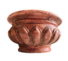 A carved pink granite planter with a leaf pattern, designed for indoor use without drainage.