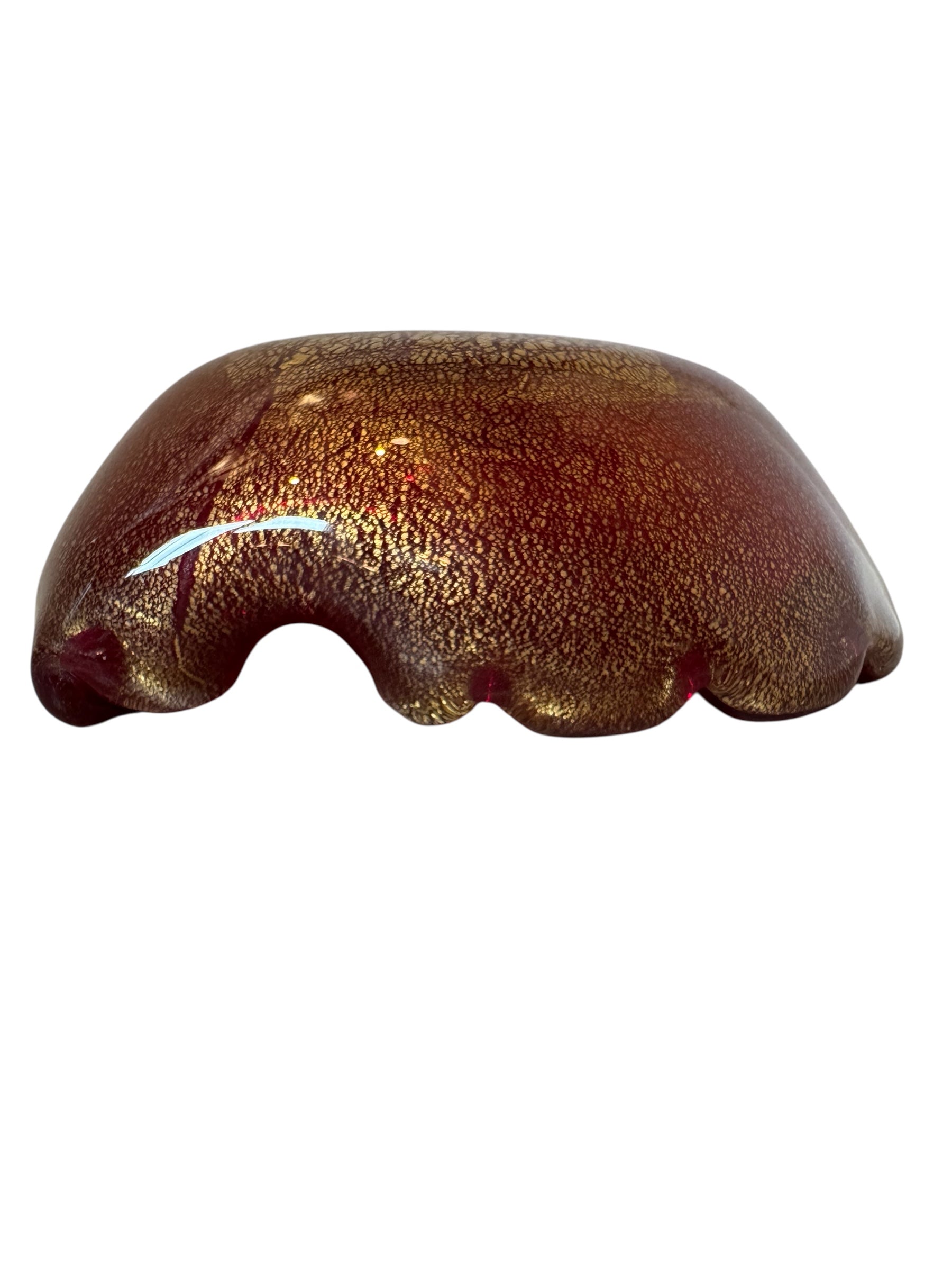 A handcrafted Murano glass bowl with a ruffled edge, deep red color, and gold specks created using the "oro zecchino" technique. The surface has a crackled gold pattern that reflects light, making it a striking decorative piece.