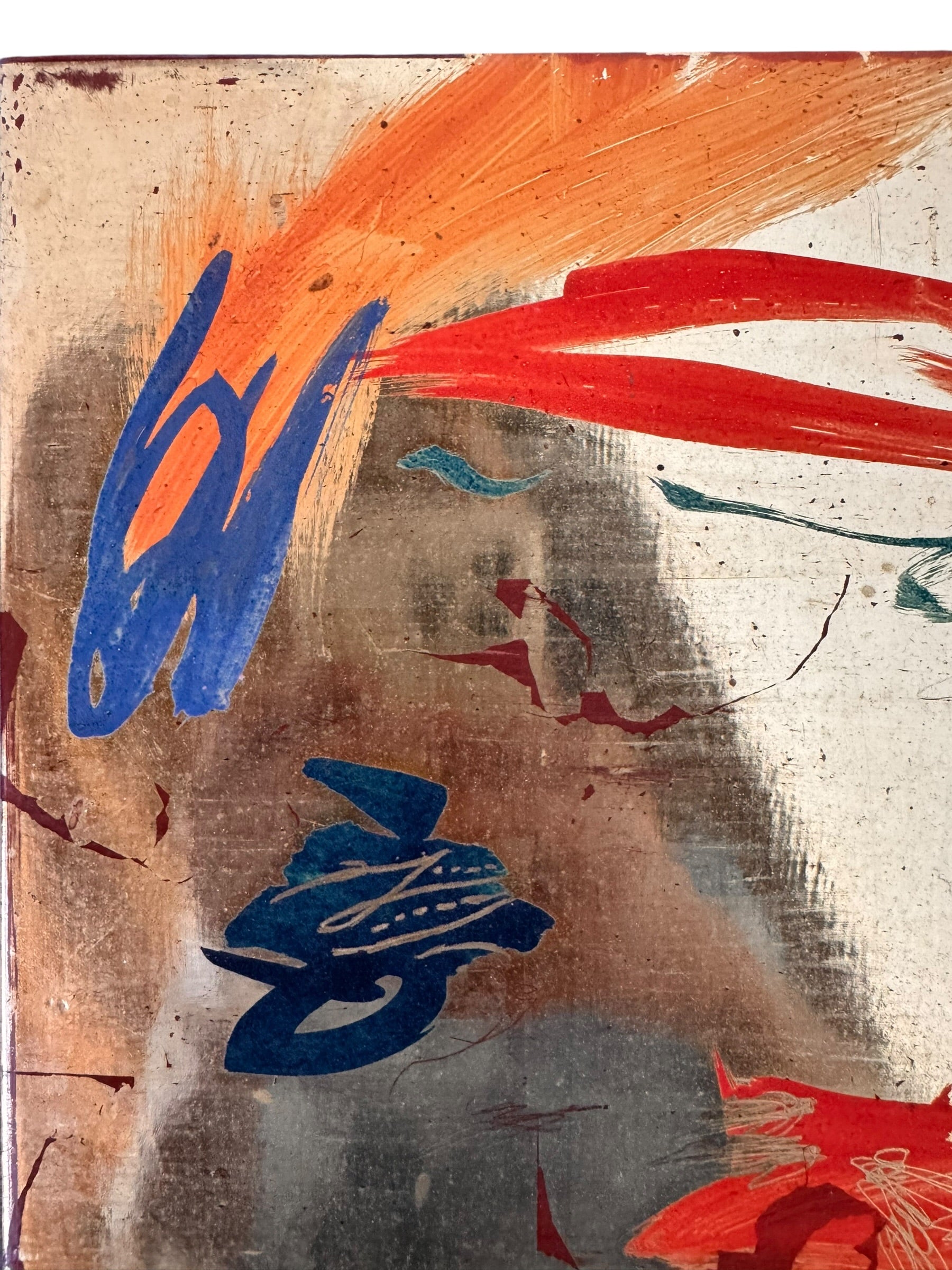 A vertical composition on a bright, reflective metallic background (likely silver or light gold leaf). The piece is defined by sparse, high-energy gestures: a sweeping arc of orange and red at the top, a central cluster of textured red paint, and a scattering of teal-blue "C" shapes and hooks. The metallic surface is highly visible, giving the piece a luminous, modern feel.