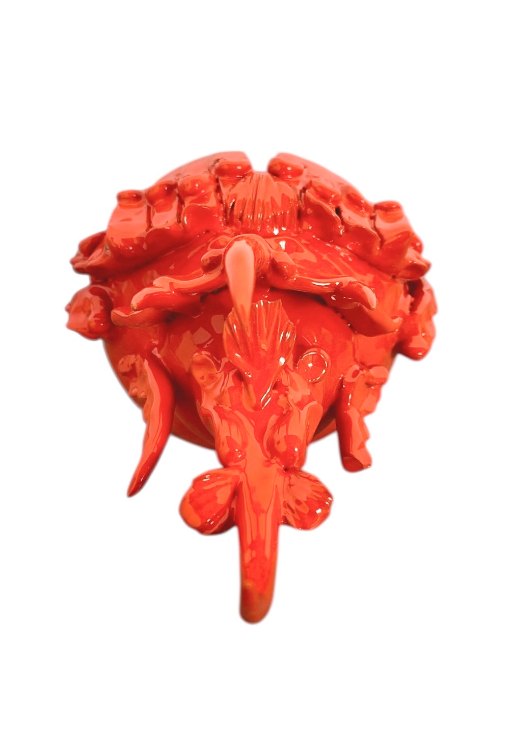 A glossy, vibrant orange ceramic sculpture of a rhinoceros beetle by Enza Fasano. The piece features a highly polished, reflective glaze and stylized, fluid anatomical details. Its prominent dual horns curve forward, and the body is textured with layered, wing-like plates, set against a plain white background.