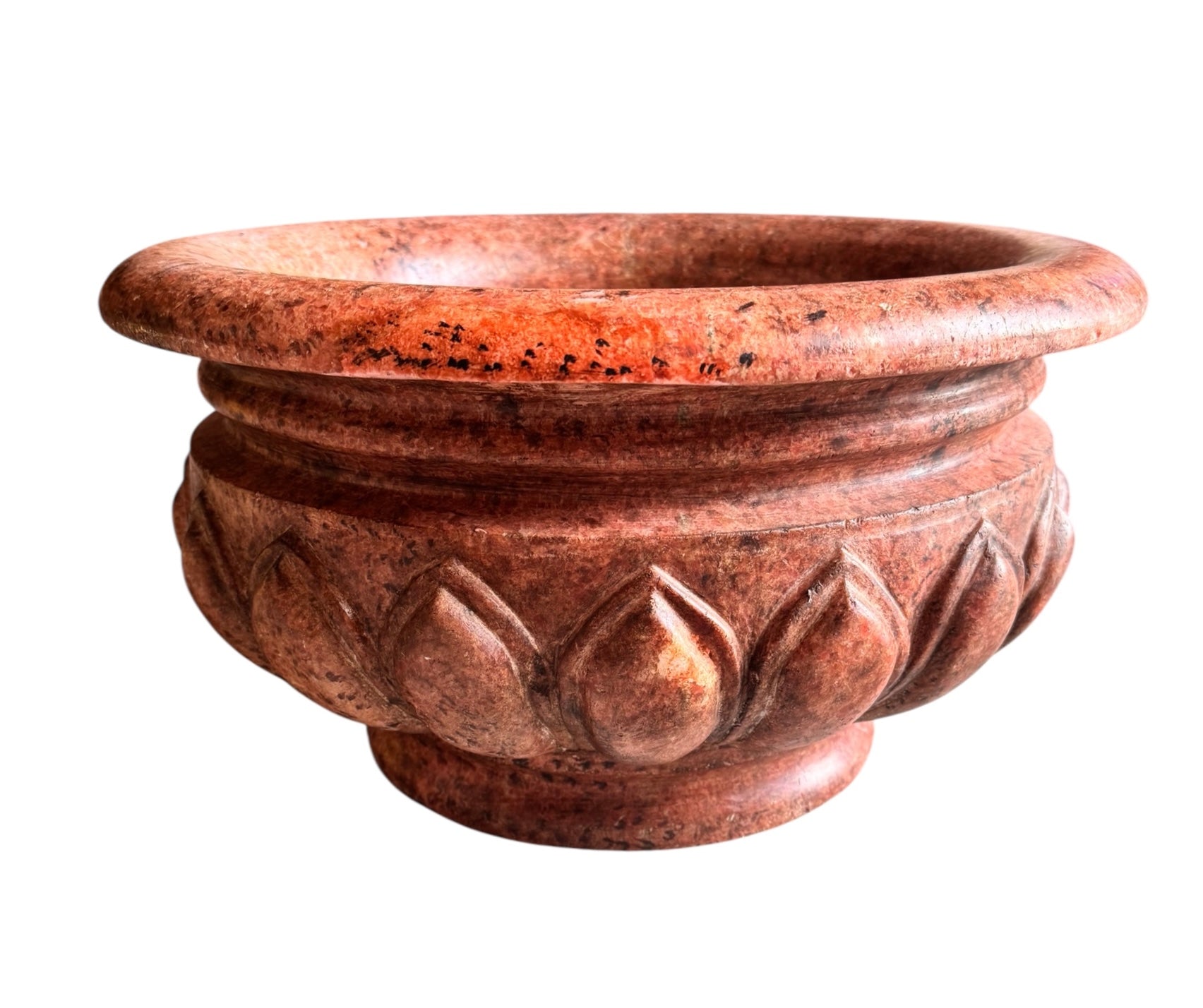 A carved pink granite planter with a leaf pattern, designed for indoor use without drainage.