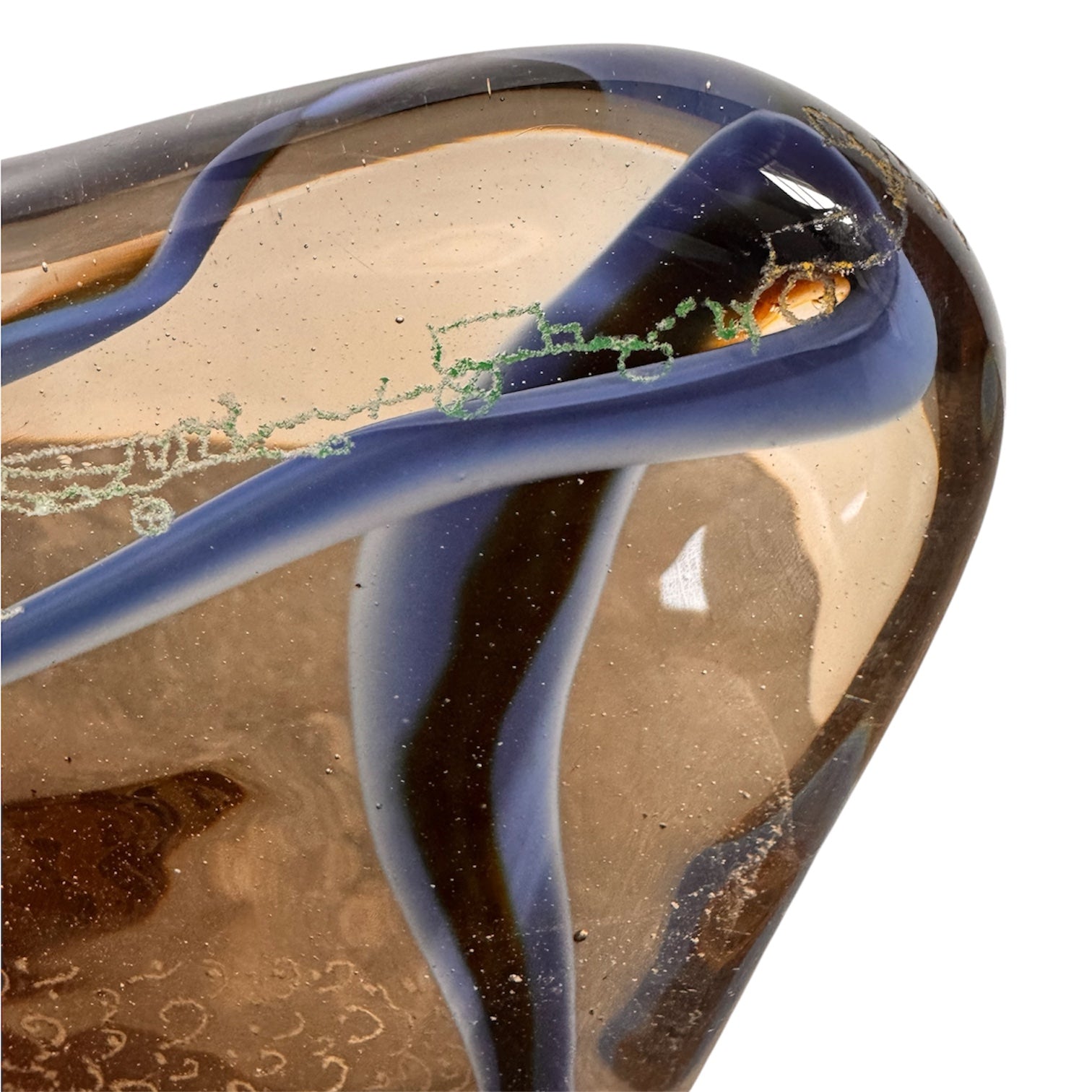 An asymmetrical Murano art glass sculpture with a heavy, biomorphic form. The piece is composed of thick, translucent smoky-amber glass with abstract, fluid bands of deep blue and dark brown swirling throughout the upper rim and sides. A dense pattern of tiny, controlled air bubbles is suspended inside the glass, concentrating heavily near the thick, solid amber base.