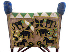 Close-up of a Yoruba beaded armchair, featuring vibrant red, blue, and green beads in a pattern of stylized masks and animals such as lions and zebras