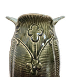 An ornate, dark glazed ceramic Art Nouveau vase with two handles and raised floral designs in yellow, purple, and green.