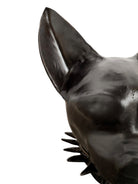 A smooth, dark black-colored ceramic sculpture of a Miniature Pinscher's head. The stylized dog features large, upright pointed ears and a prominent spiked collar around its neck. The surface has a soft sheen, with minimalist indentations for eyes and a rounded snout, creating a sleek and modern aesthetic.