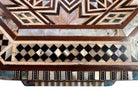 An ornate octagonal Syrian inlaid box, intricately decorated with geometric patterns made from dark wood, iridescent mother-of-pearl, vibrant abalone shell, and pale bone