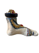 Ceramic foot sculpture by Domenico Pinto featuring hand-painted details, gold accents, a sacred heart, and an angel figure with a blindfold