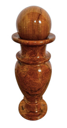 An elegant, hand-carved decorative vase made of polished Pakistani brown onyx. The vase features a classic, rounded urn shape with a tiered, flared neck and a solid matching spherical stone stopper resting on top. The stone displays rich, natural horizontal banding and swirling patterns in shades of honey, deep amber, rust-red, and cream. It stands on a small, integrated pedestal base against a clean white background, reflecting a high-gloss, mirror-like finish.