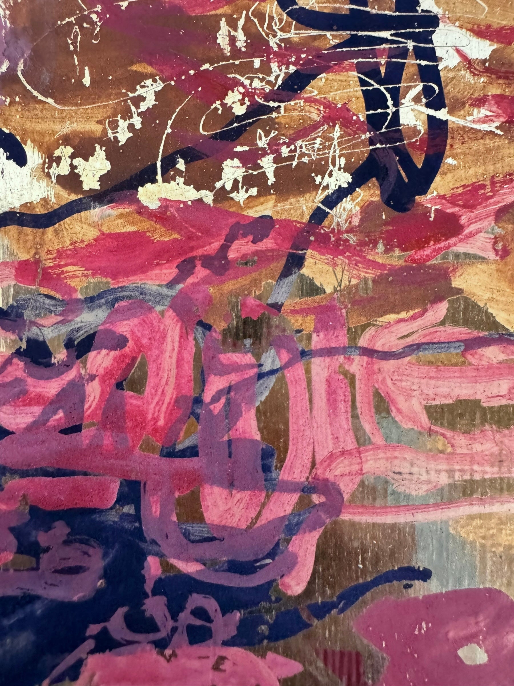A vibrant abstract painting on a metallic gold-toned panel characterized by dense, energetic layering. The palette is dominated by saturated pinks, deep blacks, and earthy oranges.
In the upper half, horizontal strokes of orange and pink suggest a sunset or landscape, while the lower half features heavy, gestural applications of black paint that anchor the composition. Fine, white or silver linear scribbles are scratched into or layered over the pigment, adding a sense of frantic movement.