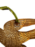 mage of a vintage-style, gilded tin bird with embossed feather detailing. A green velvet ribbon is attached. Front and back views shown.