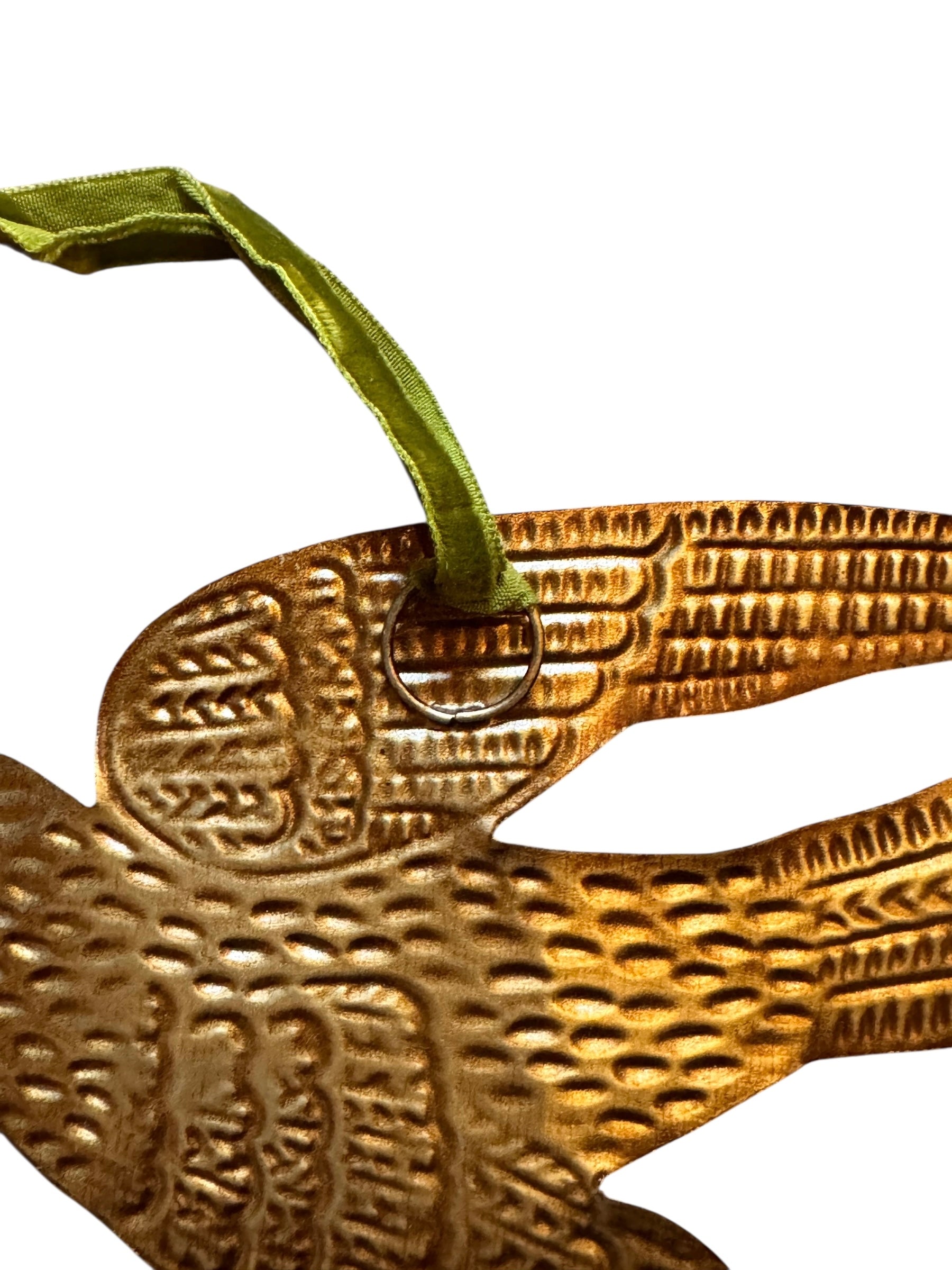 mage of a vintage-style, gilded tin bird with embossed feather detailing. A green velvet ribbon is attached. Front and back views shown.