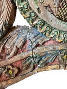 A pair of antique, heavily carved Anglo-Indian style throne chairs featuring lion figures as legs and arm supports, and peacock motifs on the backrests. The chairs have a distressed, multi-colored painted finish.