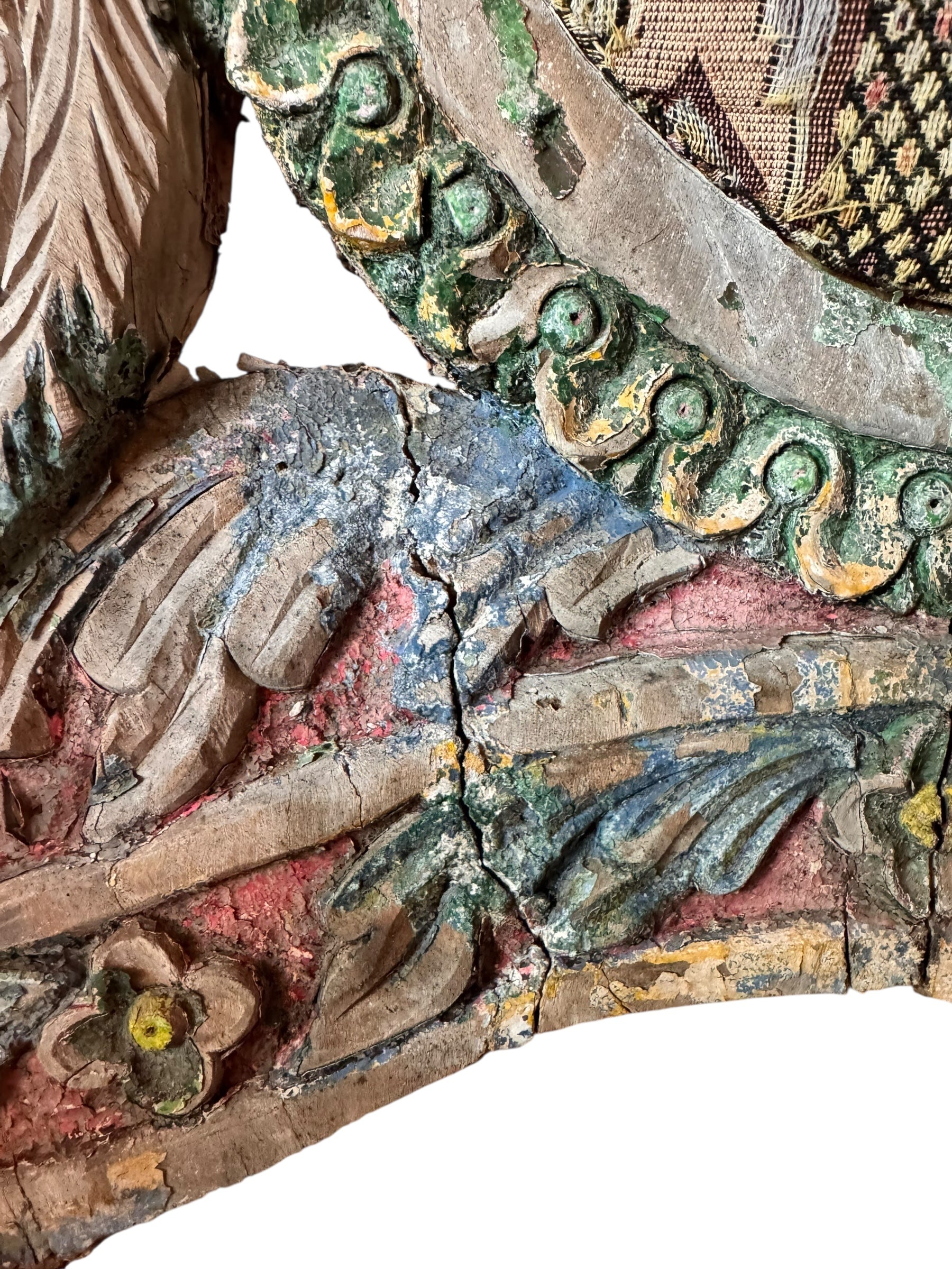 A pair of antique, heavily carved Anglo-Indian style throne chairs featuring lion figures as legs and arm supports, and peacock motifs on the backrests. The chairs have a distressed, multi-colored painted finish.