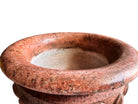 A carved pink granite planter with a leaf pattern, designed for indoor use without drainage.