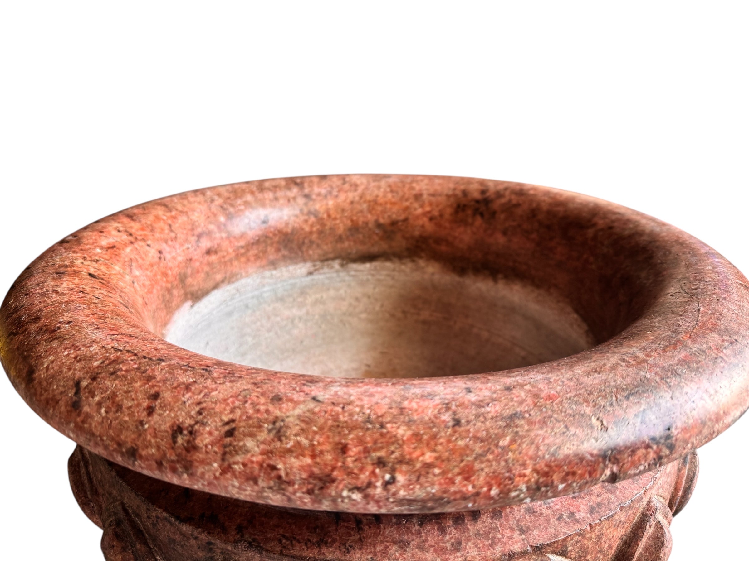 A carved pink granite planter with a leaf pattern, designed for indoor use without drainage.