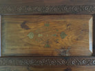 Antique bar cabinet with wood inlay and brass floral details, open to reveal interior shelving and bar storage