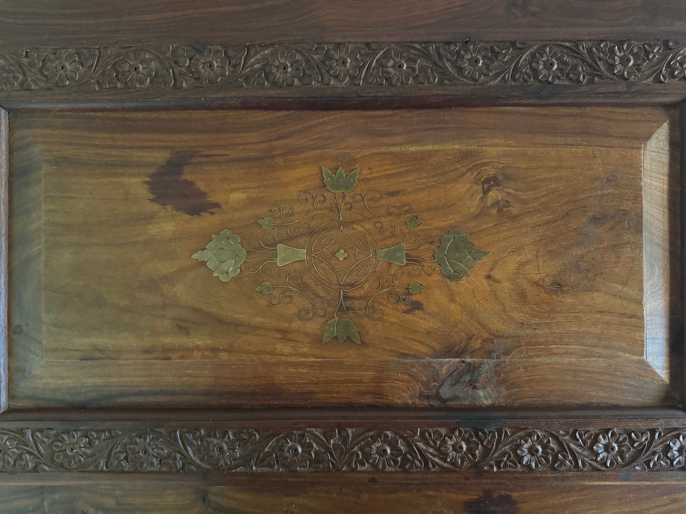 Antique bar cabinet with wood inlay and brass floral details, open to reveal interior shelving and bar storage