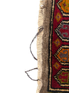 Anatolian Yastik rug with red, gold, green and gray geometric patterns and fringe.
