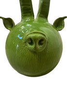 Glossy green ceramic pig sculpture with exaggerated, upward-curving horns and a snout.