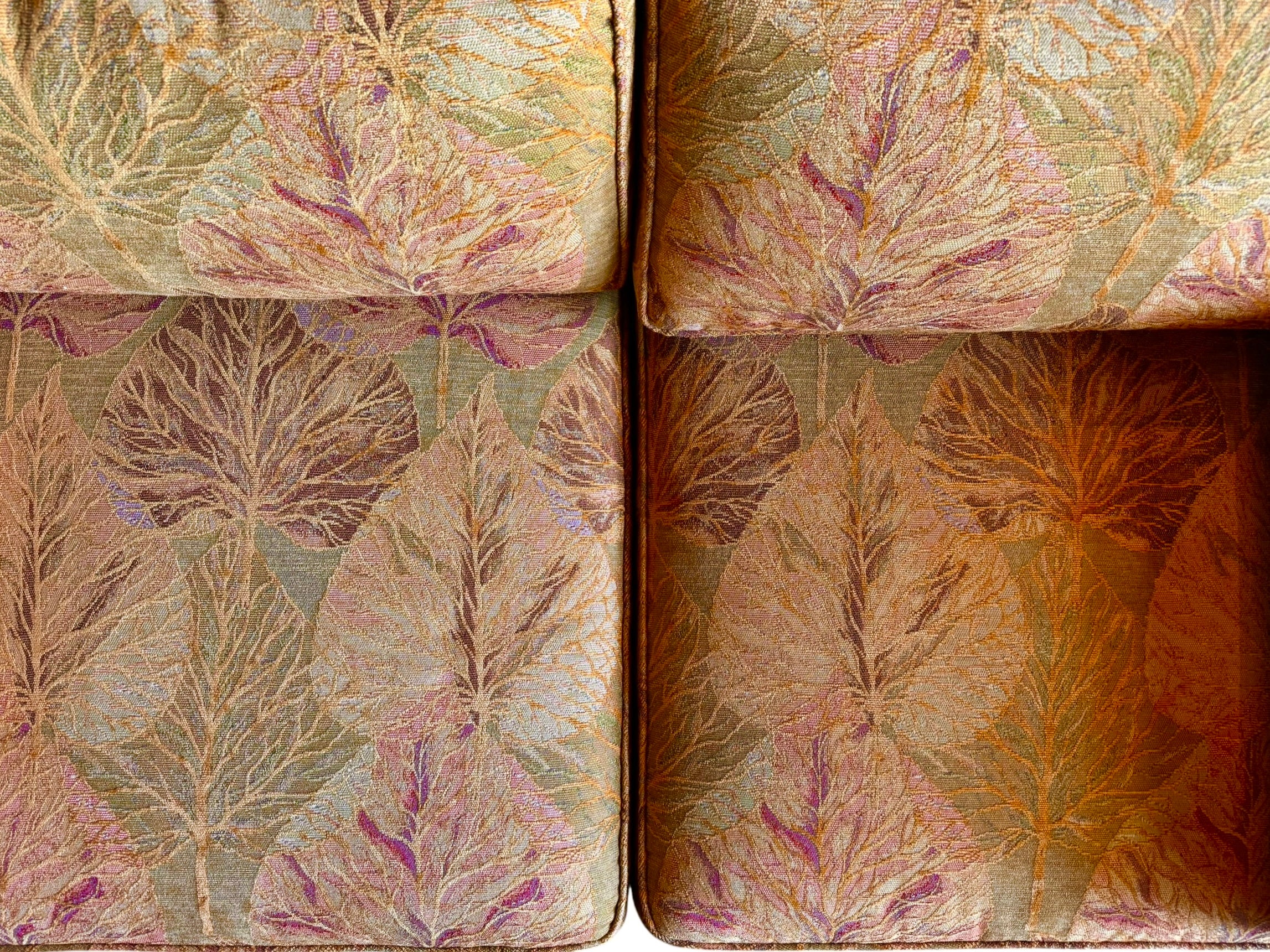 A Neoclassical-style wooden loveseat with a dark mahogany frame featuring scrolled arms and tapered legs. The upholstery consists of plush cushions and two matching cylindrical bolster pillows, all covered in a golden-yellow jacquard fabric with a large-scale, repeating autumnal leaf pattern in shades of muted orange and brown.