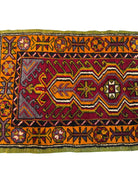 Anatolian Yastik rug with red, gold, green and gray geometric patterns and fringe.
