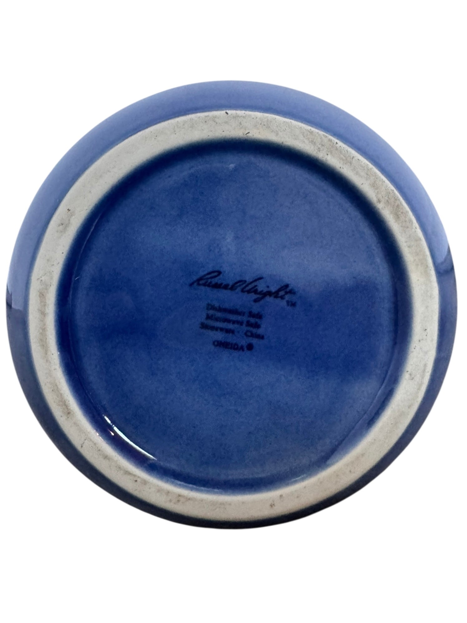 A Russel Wright American Modern stoneware water pitcher in a glossy Manitoga blue glaze is centered against a white background. The pitcher has a teardrop shape, a large handle, and a wide spout