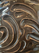 Glossy dark brown ceramic bull sculpture with intricate, hand-incised swirling patterns and a nose ring.