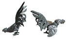 A pair of vintage, silver-plated brass fighting rooster figurines positioned in a confrontational stance against a white background. The rooster on the left is crouched low with its head down and tail feathers fanned high, while the rooster on the right stands more upright with its wings slightly flared. Both feature intricate feather detailing, a metallic patina showing hints of brass through the silver, and small, bright red glass eyes.
