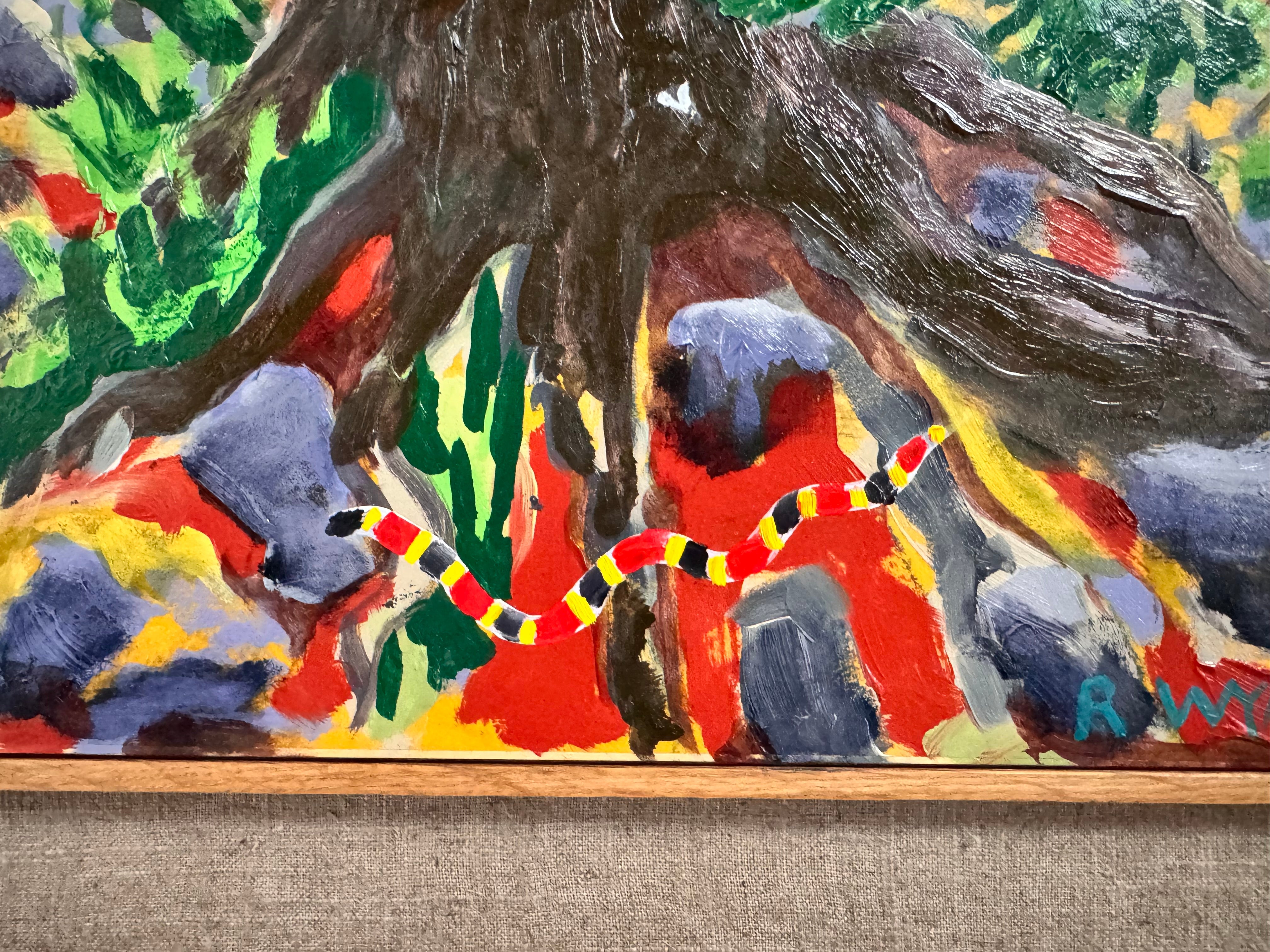 A vibrantly colored landscape painting titled 'Perdernales Falls Fisherman,' featuring two large trees with prominent exposed roots framing a body of water. A lone figure, a fisherman, stands by the water in the middle ground. The painting uses bold strokes of yellow, green, red, and blue, and is enclosed in a rustic dark wooden frame with a light-colored inner mat.