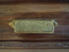 Antique bar cabinet with wood inlay and brass floral details, open to reveal interior shelving and bar storage