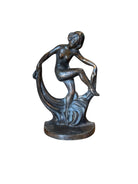 Two cast iron bookends in the Art Deco style. Each features a nude female figure leaning gracefully with one leg extended, posed atop a stylized wave or drape. The bookends have a bronze-colored finish and a vintage appearance.