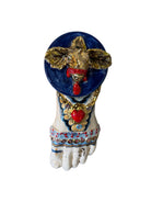 Ceramic foot sculpture by Domenico Pinto featuring hand-painted details, gold accents, a sacred heart, and an angel figure with a blindfold