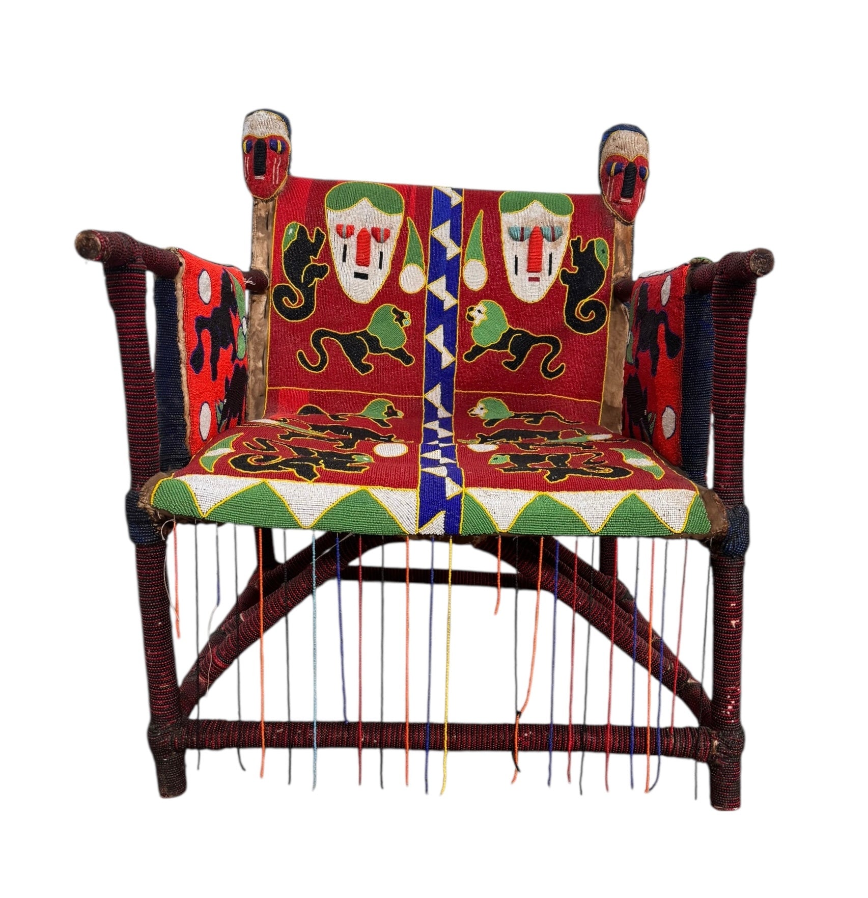 Close-up of a Yoruba beaded armchair, featuring vibrant red, blue, and green beads in a pattern of stylized masks and animals such as lions and zebras