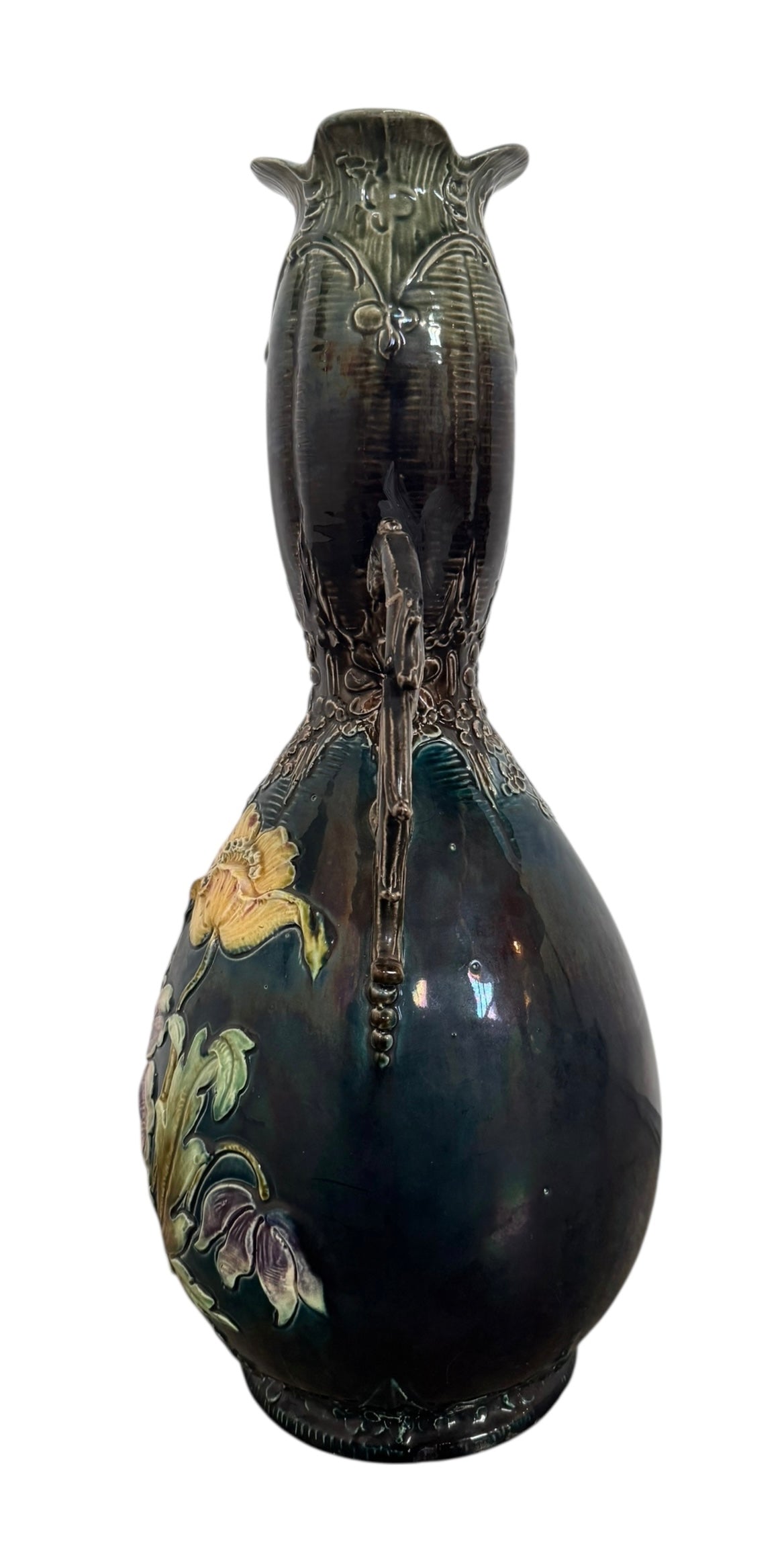 An ornate, dark glazed ceramic Art Nouveau vase with two handles and raised floral designs in yellow, purple, and green.