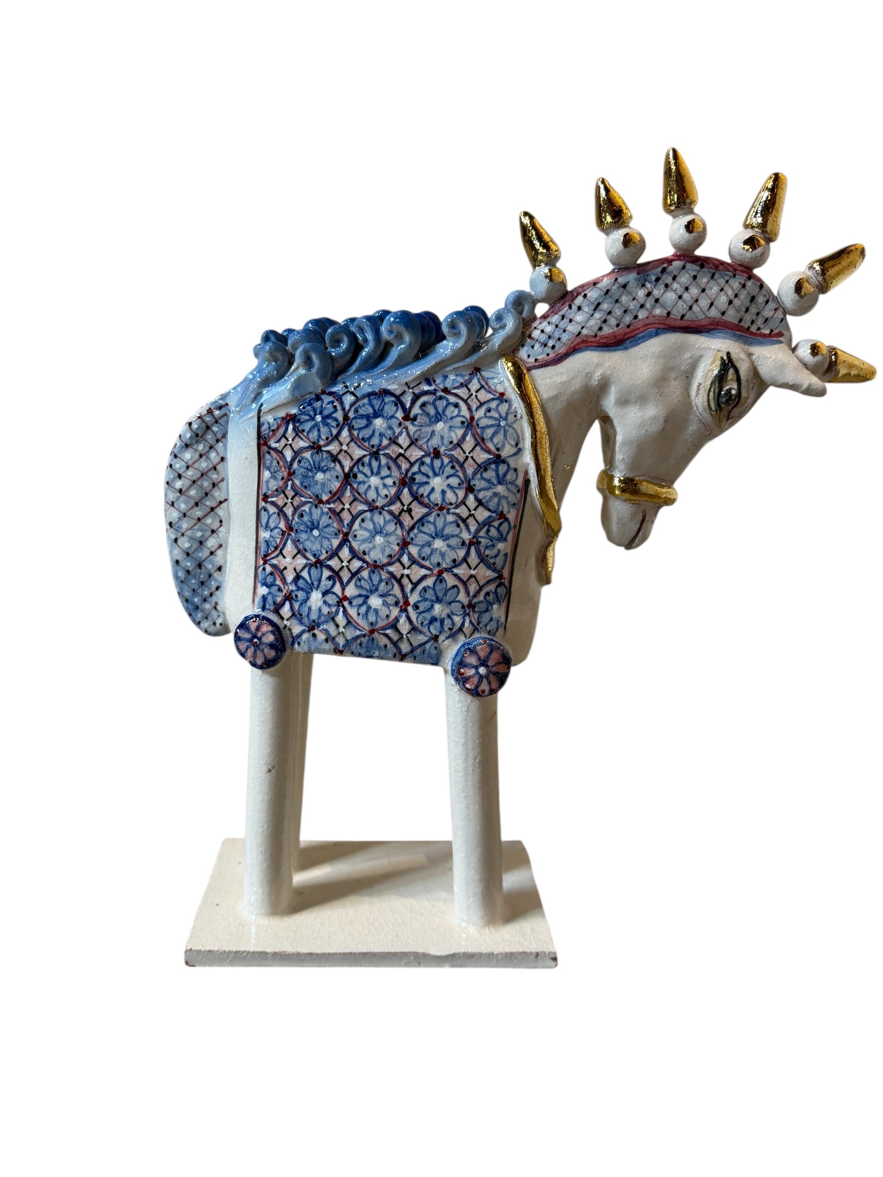 Ceramic horse by Domenico Pinto, featuring a white glazed body, geometric quilting on the saddle, a decorative crown with white and gold accents, and 24Kt gold detailing. The horse stands on four legs and is placed on a white base.