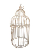 A single, white or cream-colored, decorative wrought iron bird cage with a hinged door and a hanging loop at the top. The cage has a vintage or antique style 