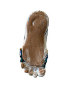 Close-up of Domenico Pinto's 'Mare Dentro' ceramic sculpture: foot, ship with gold sail, Apulian style