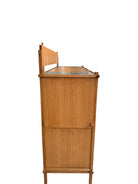 A three-tiered wooden shelving unit featuring a mix of light oak and teal-colored panels. The piece has an open, structural design with visible joinery, vertical supports that extend past the top shelf, and a horizontal backrest at the top. The middle and bottom shelves feature slatted wood center sections flanked by solid teal panels, while the top surface is primarily solid wood with teal accents at the edges.