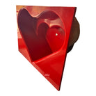 A top-down, straight-on view of a vintage, high-gloss cherry red bathtub. The tub basin is molded into a distinct double-tiered heart shape, with a shallower outer heart cascading into a deeper, smaller inner heart basin centered within a wide rectangular red deck.