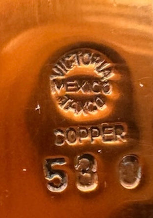 The set includes a large, rectangular, hammered copper tray with geometric openwork handles. Resting on the tray is a tall, slightly tapered copper coffee pot with a wooden handle, a matching smaller creamer pitcher with a similar wooden handle, a lidded sugar bowl, and a tiny matching metal cup or jigger. To the right off the tray sits a large, spherical copper water pitcher or jug with a wide mouth and ice lip.