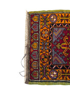 Anatolian Yastik rug with red, gold, green and gray geometric patterns and fringe.
