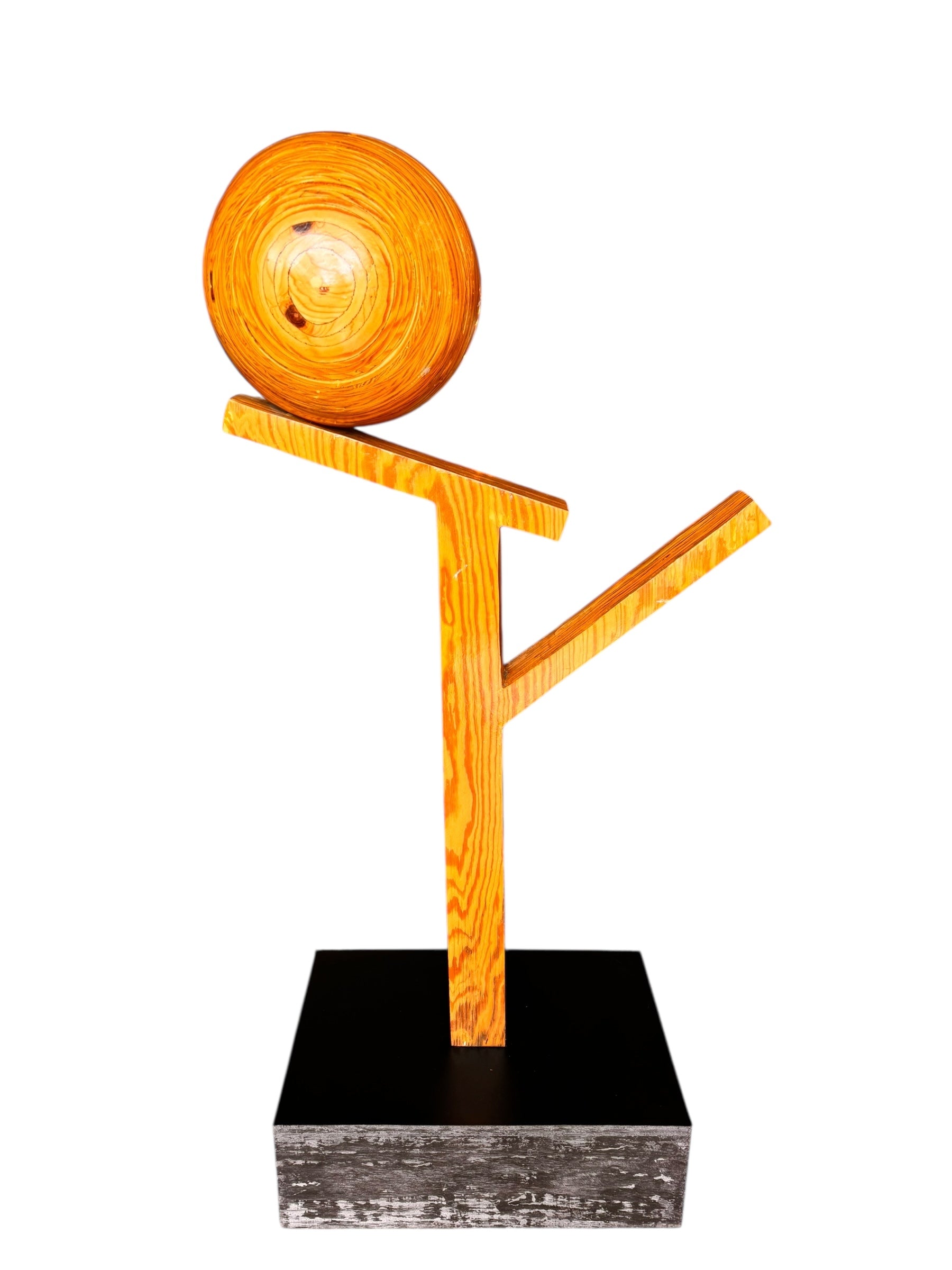 A wooden sculpture featuring a dark square base, a vertical trunk that branches into two angled supports, and a turned wooden sphere resting on the higher support.