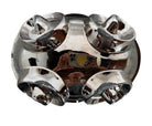 A large, decorative ceramic bowl by Dolbi Cashier in a dramatic Postmodern style. The top half is finished in a polished, piano-black glaze with an organic, wavy "butterfly" rim that dips in the center and rises at the sides. The bottom half is finished in a reflective, metallic silver chrome glaze, featuring bold, geometric-rounded feet and a structured base that appears to "hold" the black vessel. The overall shape is wide and sculptural, reminiscent of 1980s Art Deco Revival.