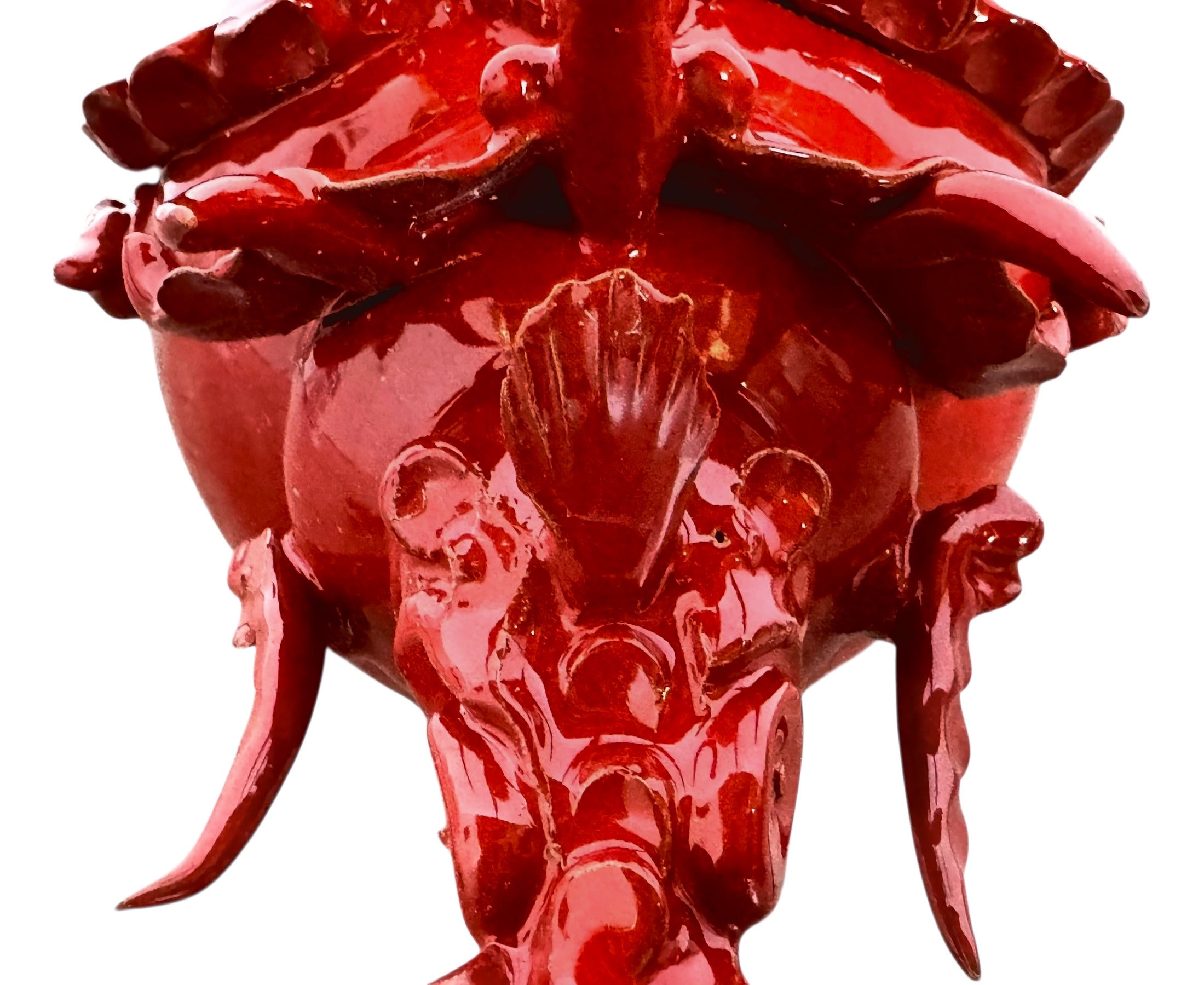 A vibrant, glossy red ceramic sculpture of a rhinoceros beetle by Enza Fasano. The piece features a highly reflective, deep crimson glaze that accentuates its smooth, rounded abdomen and the intricate, jagged textures of its head and horns.